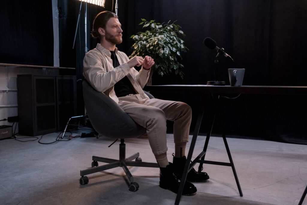 Business man sitting on a chair beside black microphone